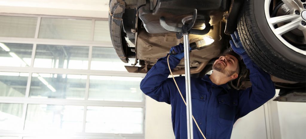 mecánico en un taller reparando un coche
